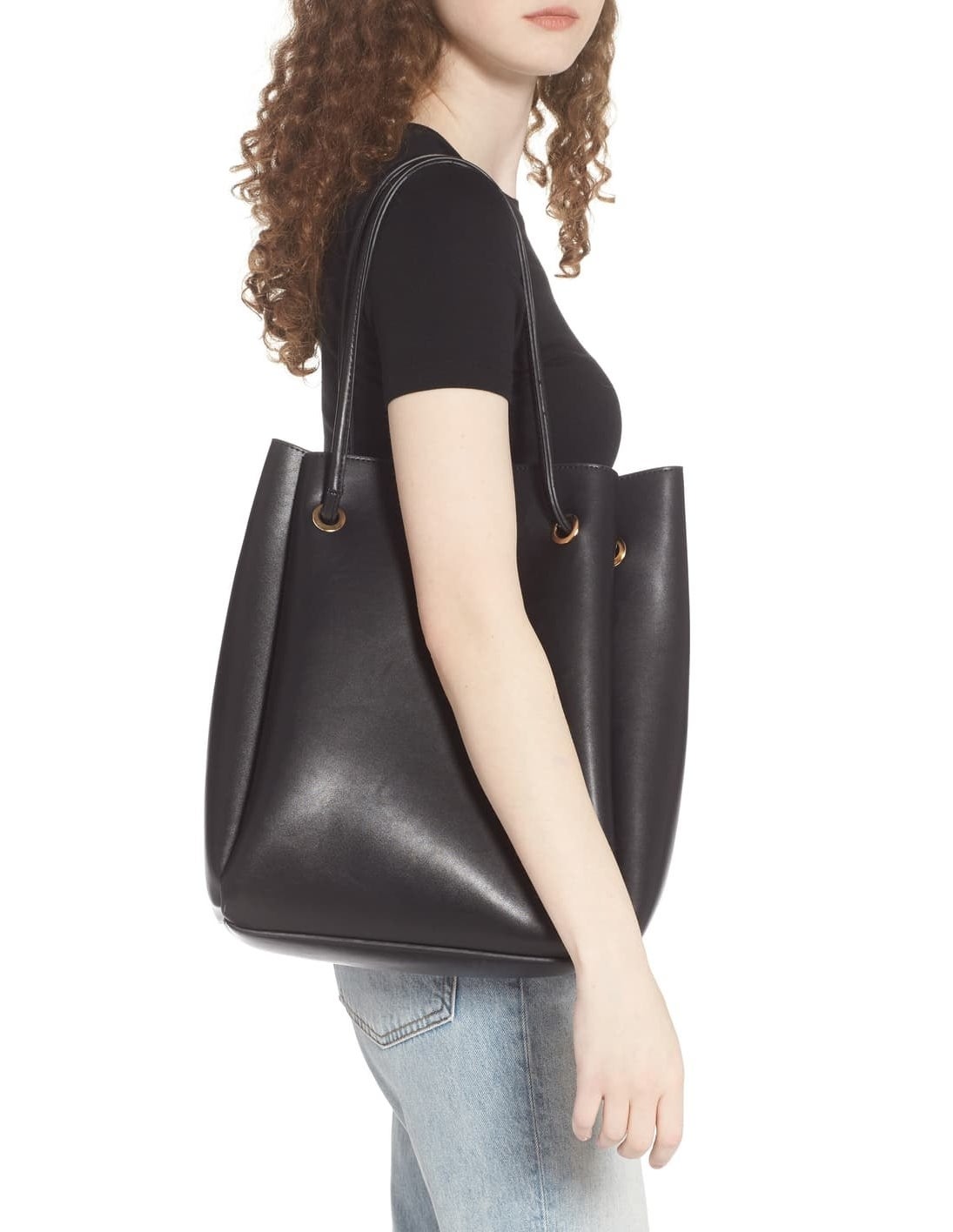 model carrying black tote bag