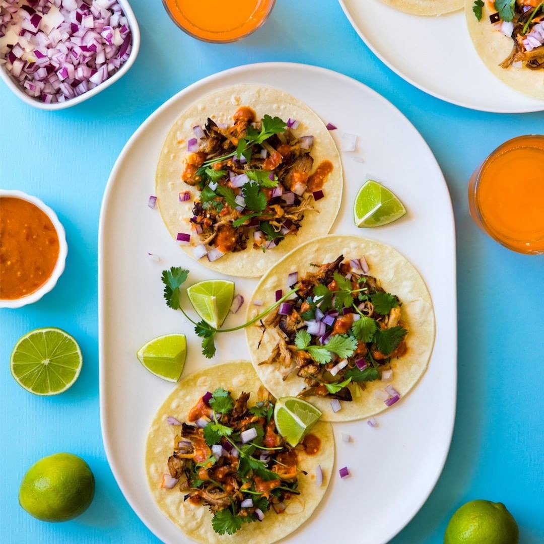 Tacos with lime wedges on a plate