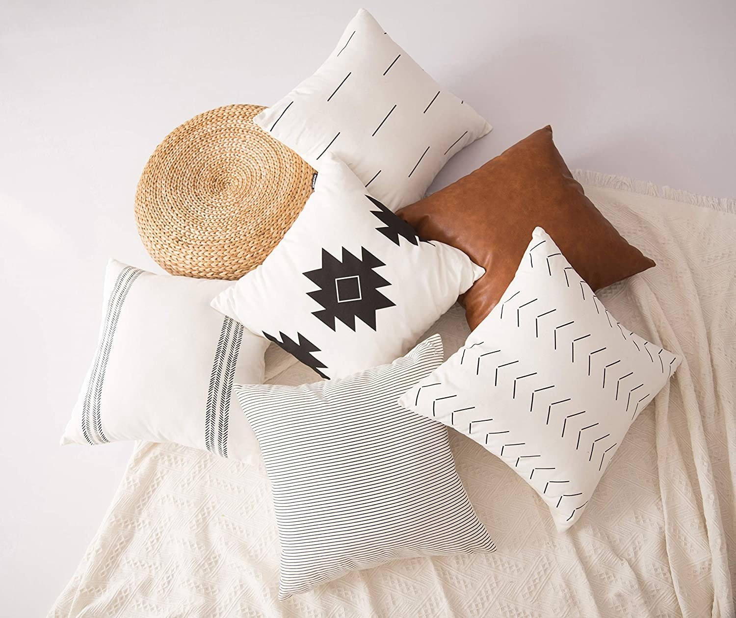 throw pillows with various patterns arranged on a blanket 