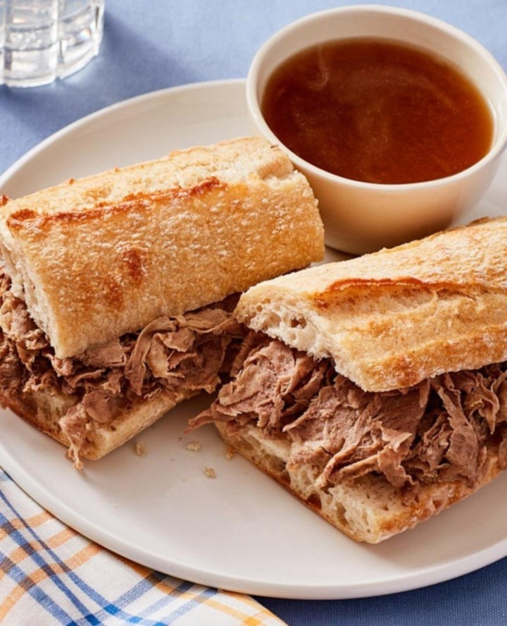 A pulled meat sandwich with a dipping sauce