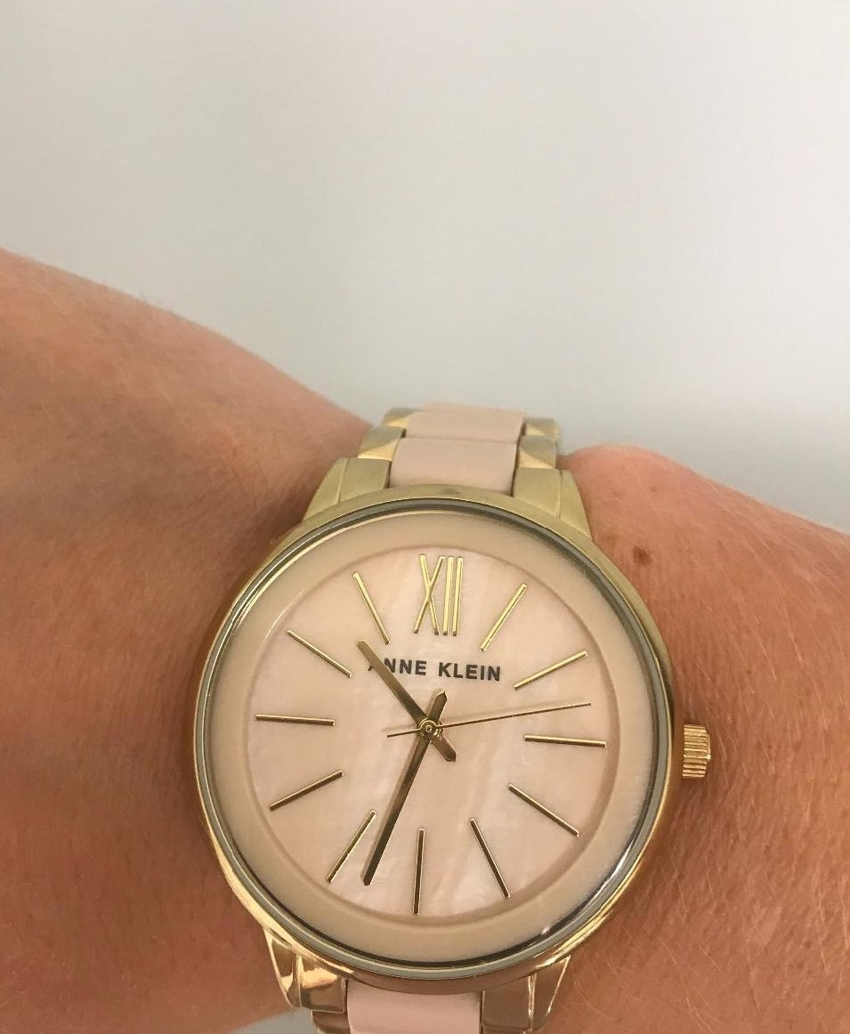 Reviewer wearing the round-face watch in pink and gold