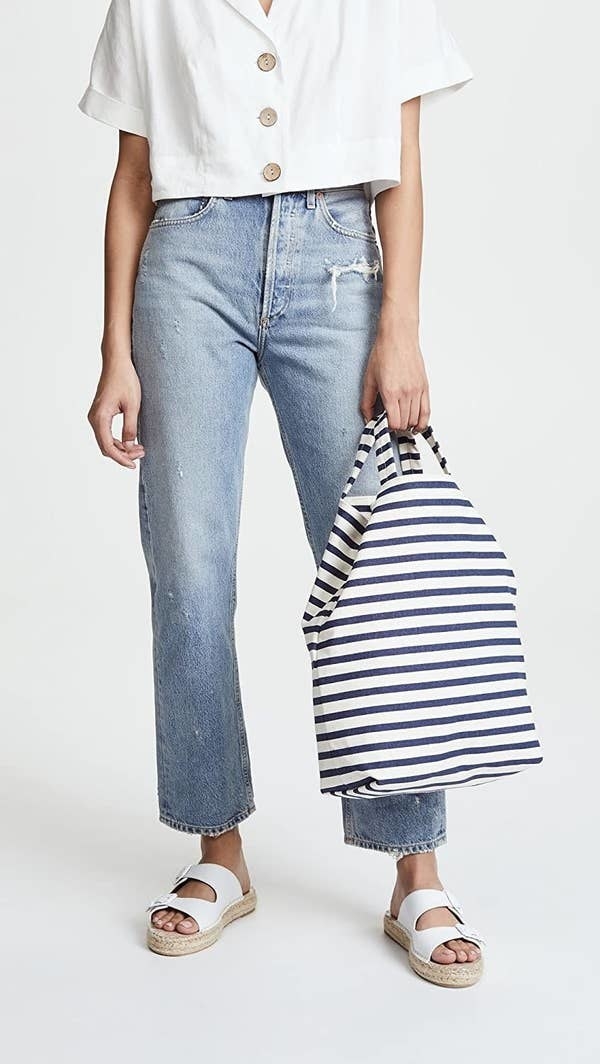 Model carrying the blue and white striped bag