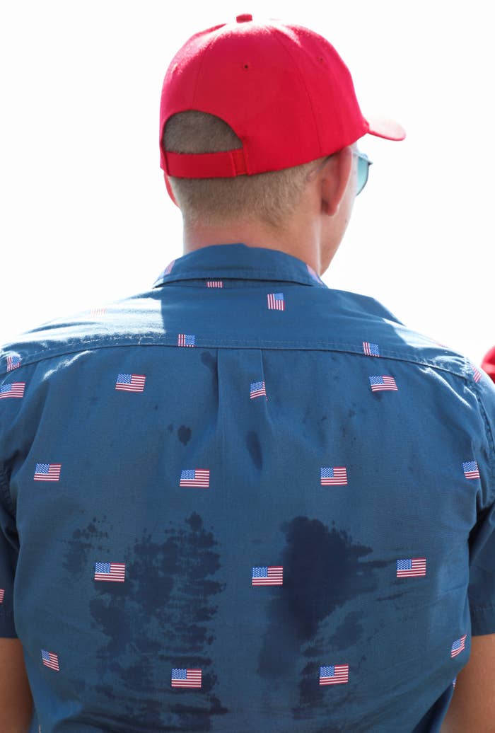 A Trump supporter wears a blue, sweat-stained shirt decorated with American flags