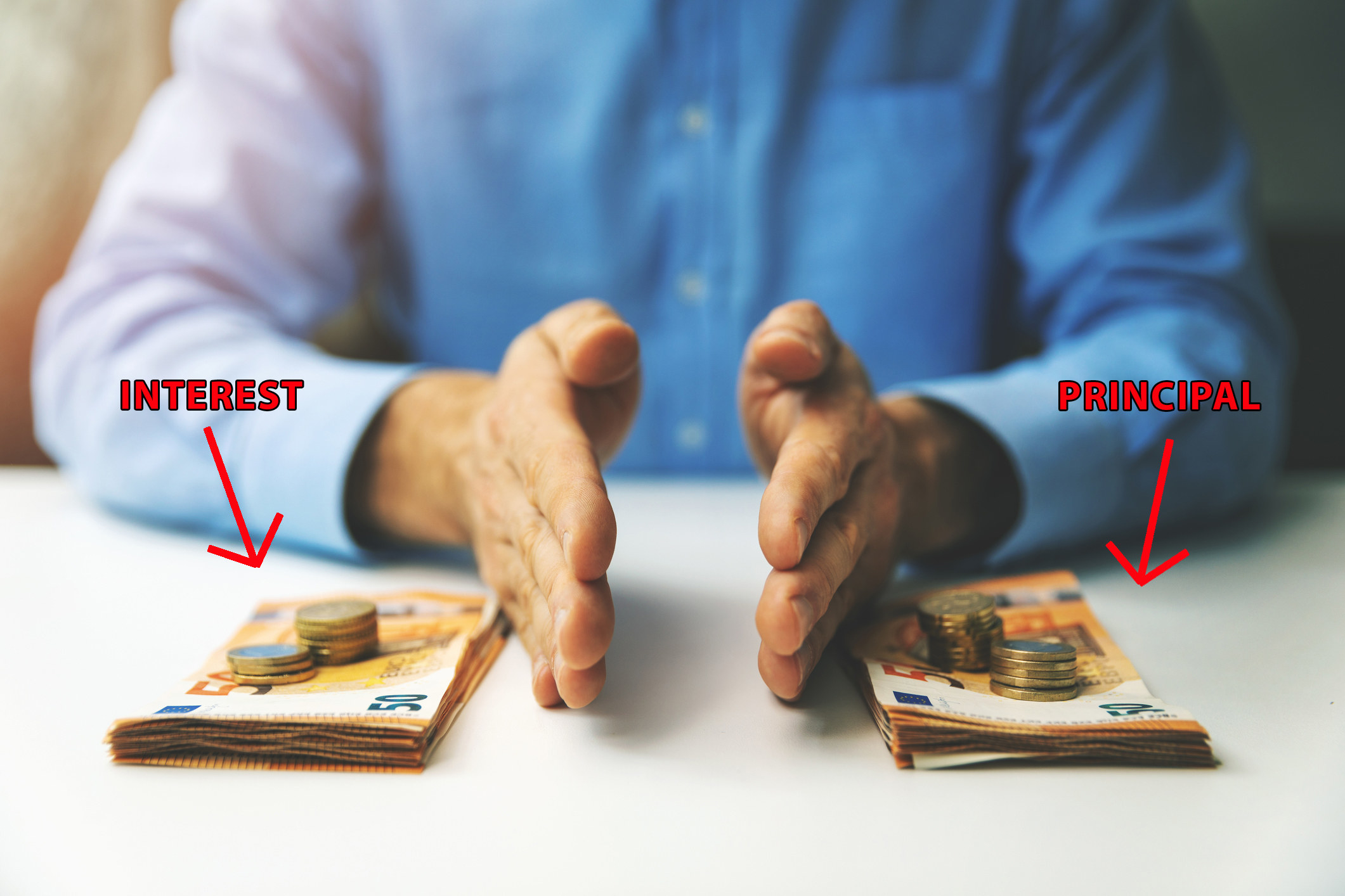 A man&#x27;s hands cut between two equal piles of money with arrows reading, respectively, &quot;interest&quot; and &quot;principal&quot; 