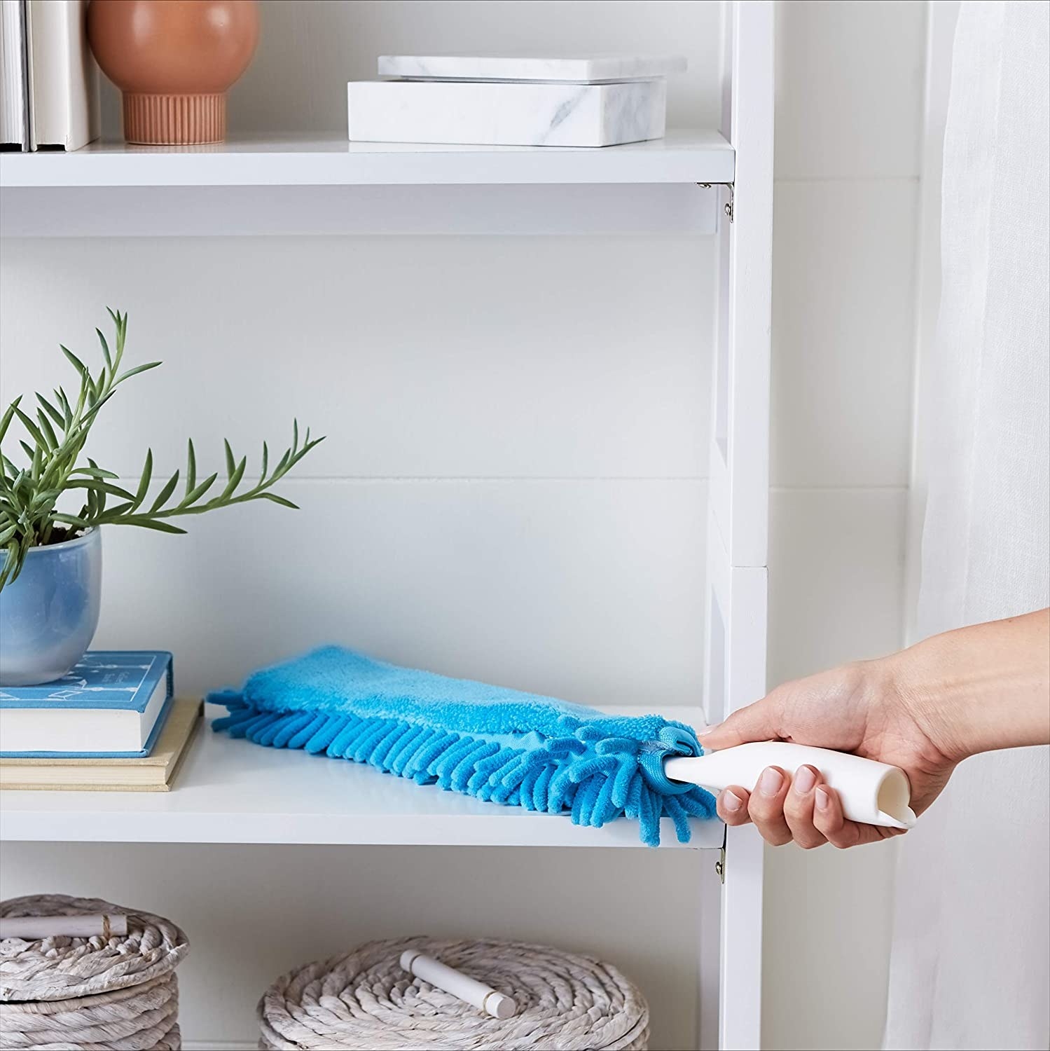 A duster cleans off a shelf