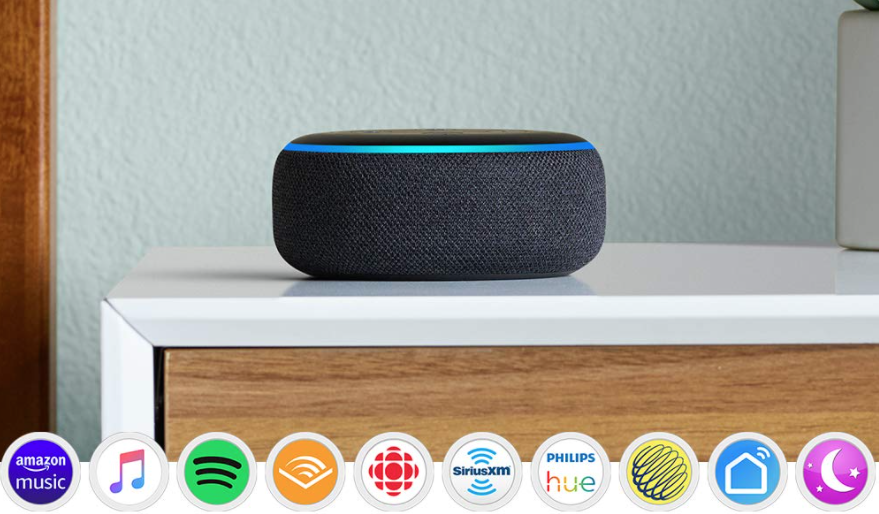 A Echo dot sitting on a bedside table