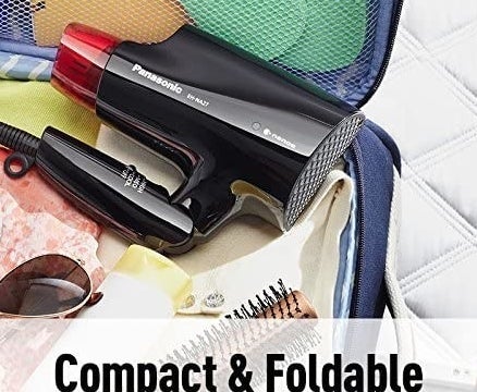 The compact hair dryer folded and placed inside an open suitcase