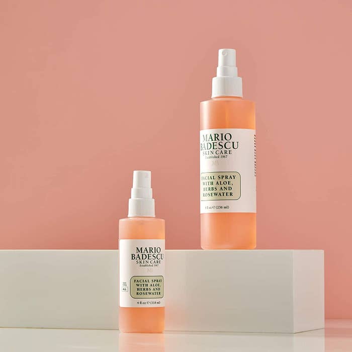 Two bottles of the facial spray on a ledge against a simple backdrop