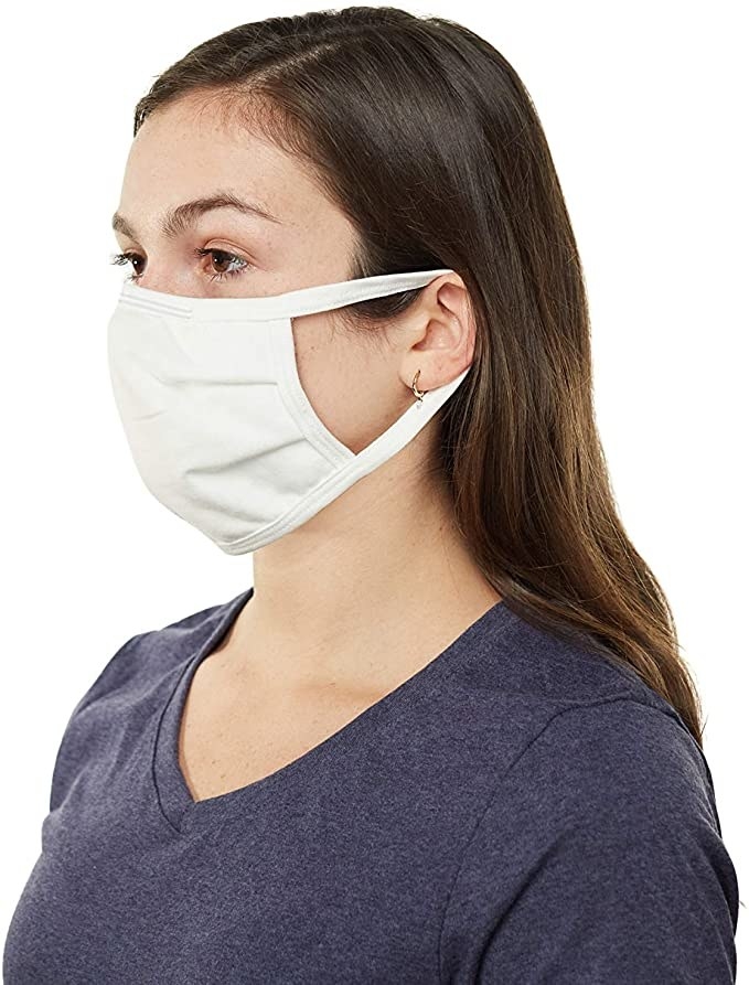 A person wears a face mask with elastics around their ears