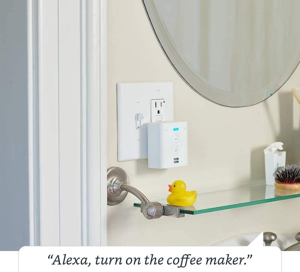 A Echo Dot placed in a outlet in a bathroom