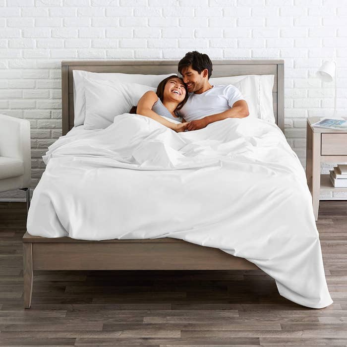 Models in bed with white sheets