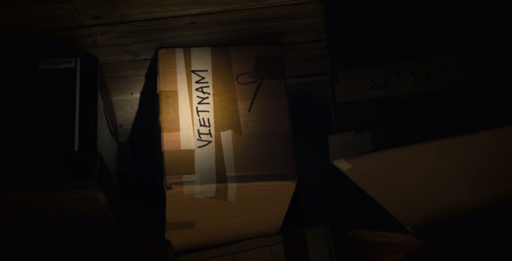 A dark room with a flashlight hilighting a box with the word &quot;Vietnam&quot; written on it