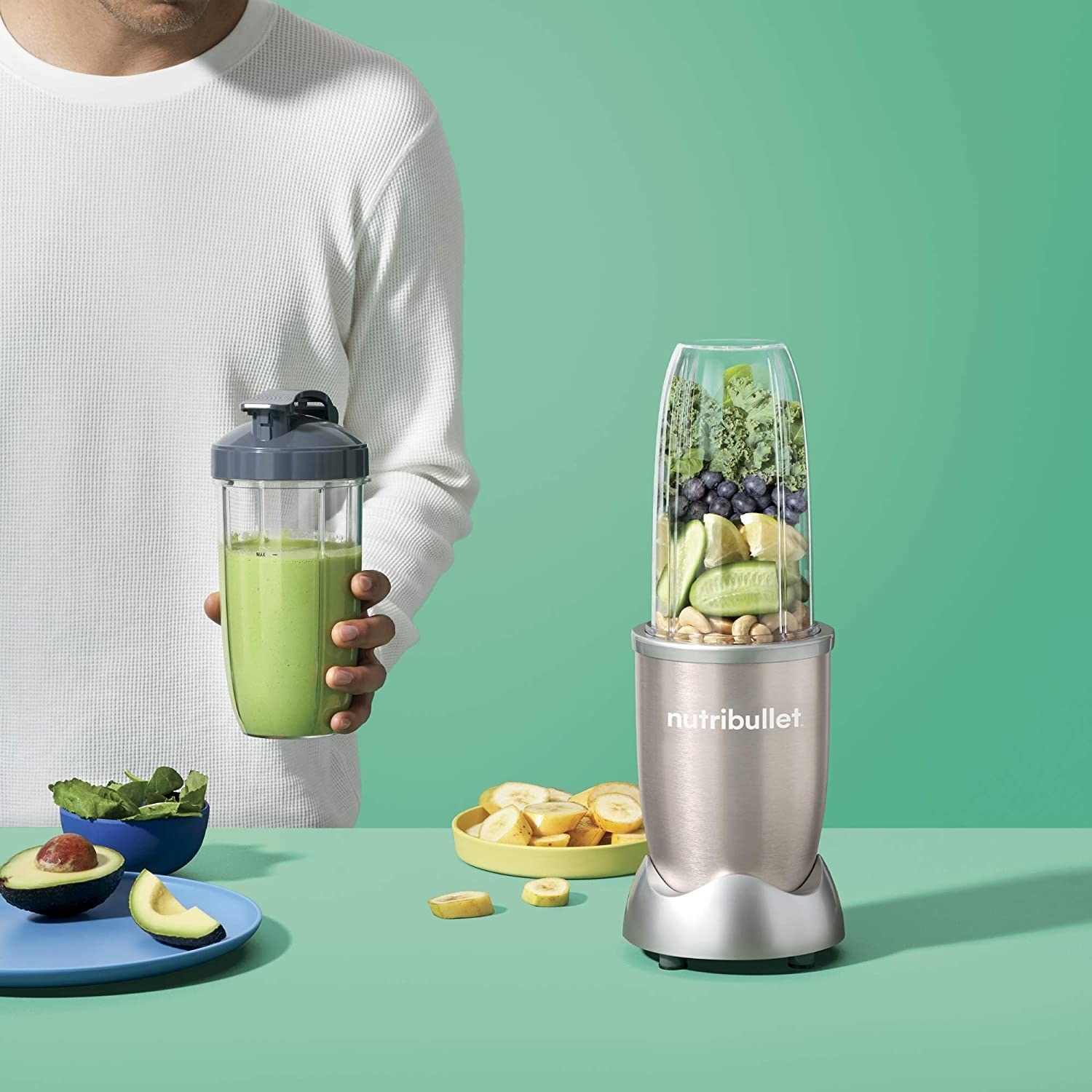 A person holding a kale smoothie next to the Nutribullet