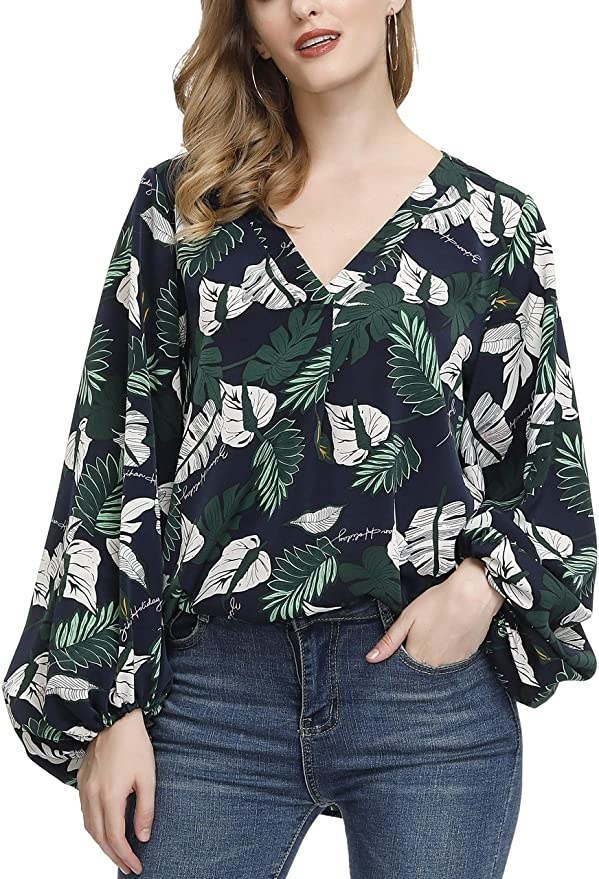 Model wearing long sleeve blouse with balloon sleeves and a dark blue and green botanical print