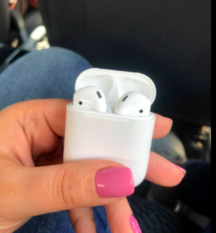 a reviewer showing off their new AirPods