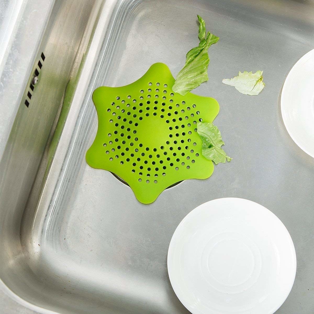 The drain stopper filtering out bits of lettuce in the sink.