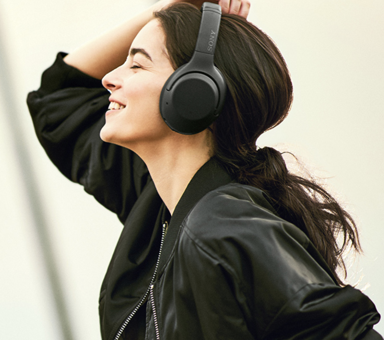 Model in black over the ear headphones
