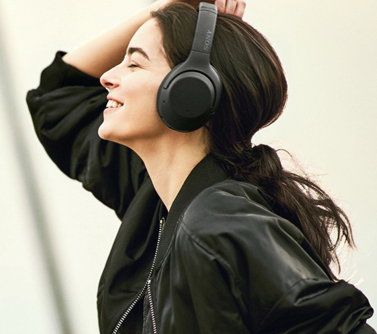 Model in black over the ear headphones 