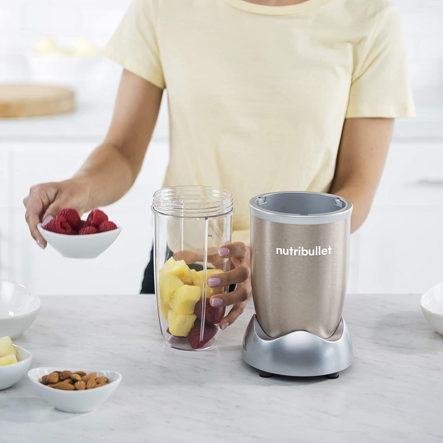 A person putting fruit into the blender cup