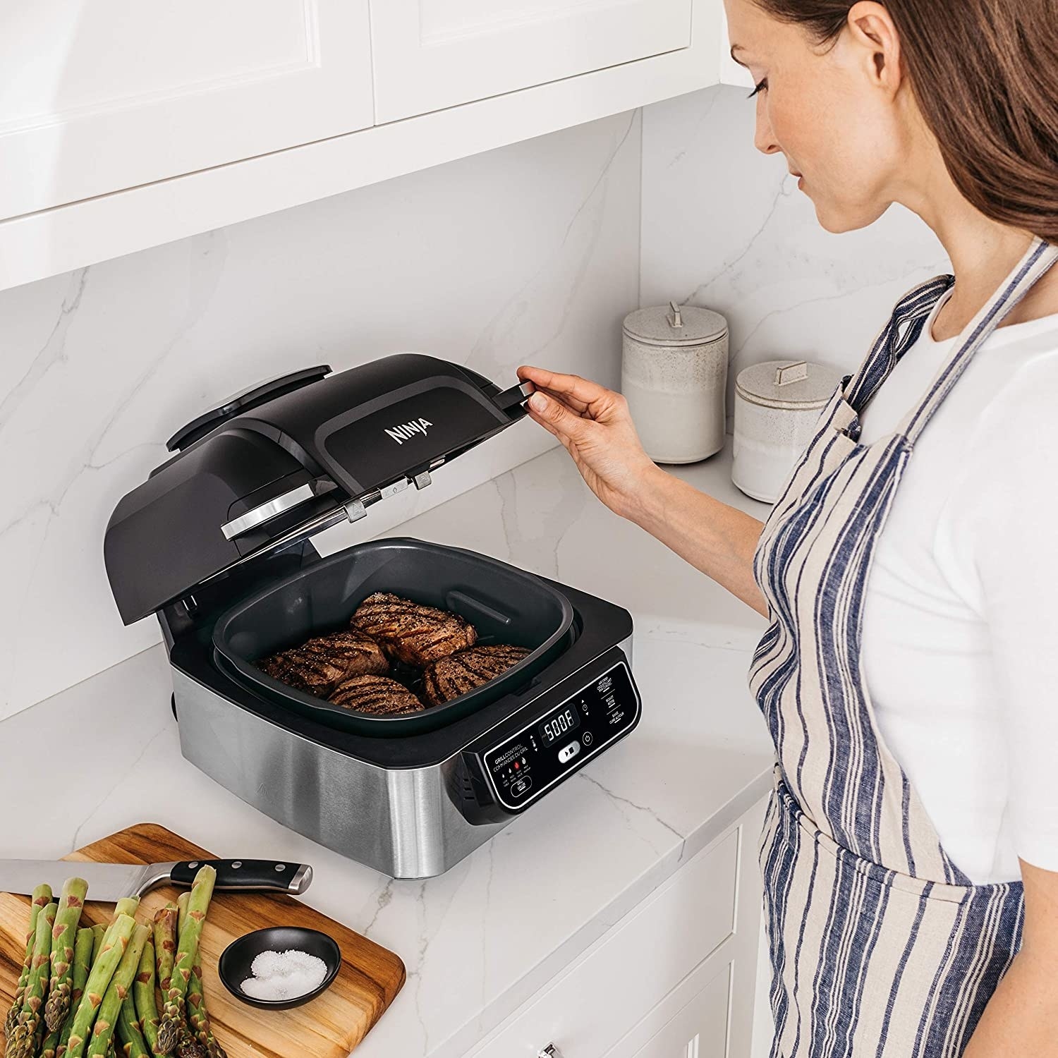 A NInji foodie grill with steaks cooking in it