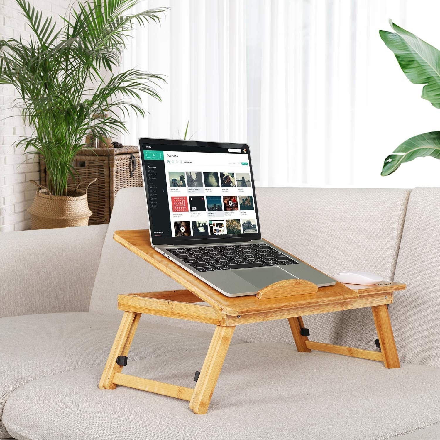 bamboo laptop desk with a laptop on it propped up on a sofa