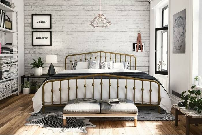 gold metal bed frame in a light-filled bedroom