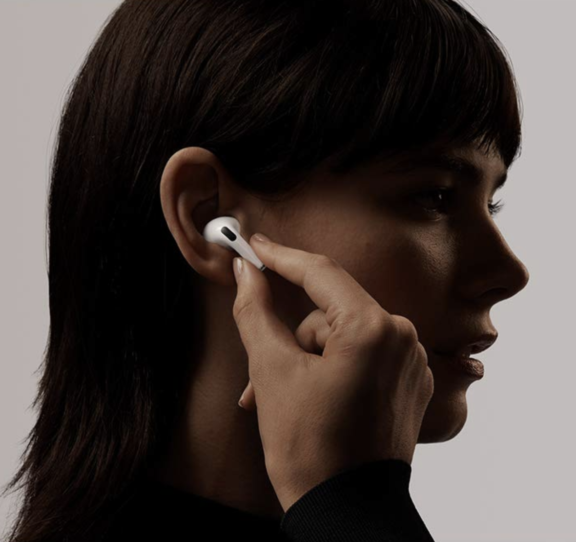 模型将白色AIrPods Pro耳塞放入耳朵