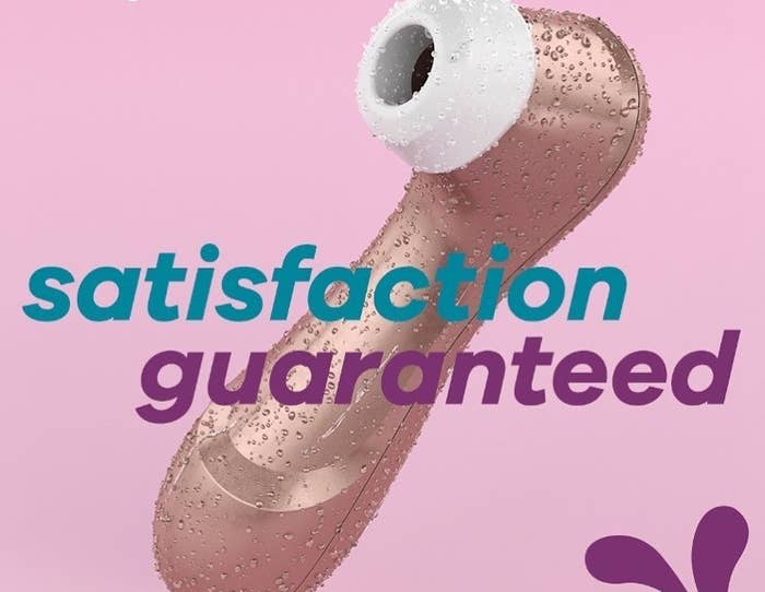 The Satisfyer Pro 2 covered in water droplets with text that reads &quot;satisfaction guaranteed&quot;