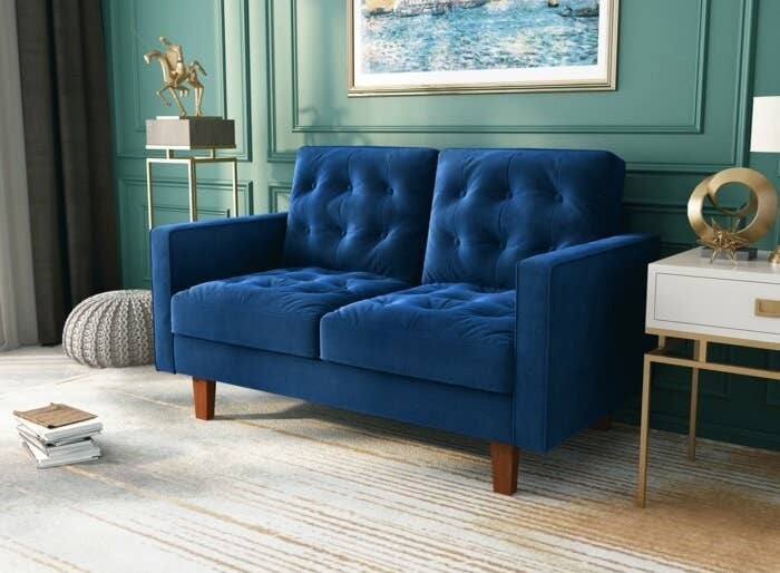 blue loveseat with tufted cushions