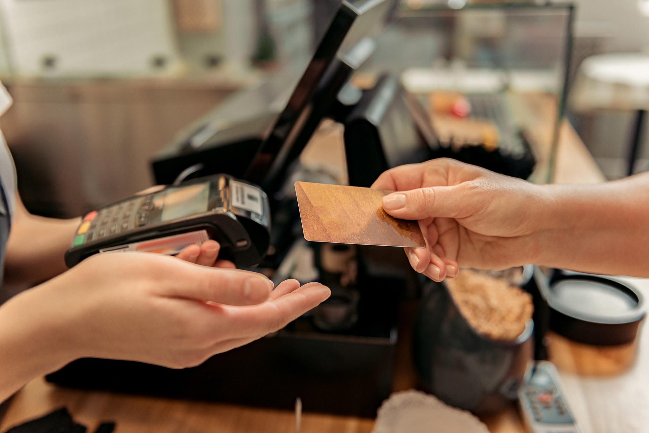 A person handing a card to a cashier
