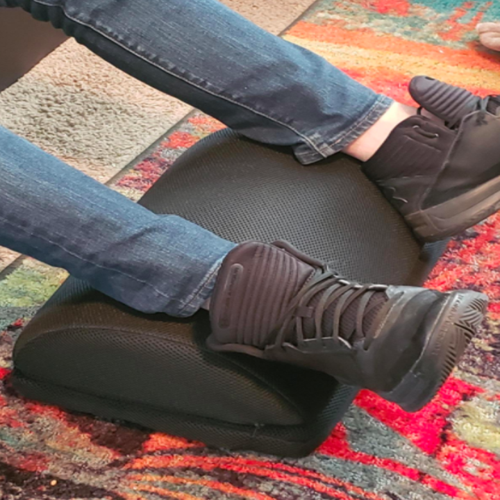 A reviewer photo of their legs/feet propped up against the foot rest