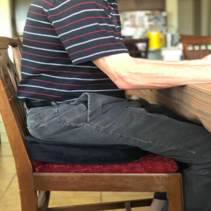 an elderly man sitting on the cushion in a chair
