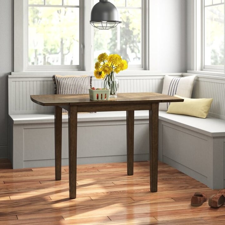 Wood dining table with drop leaves up and extended  in a dining nook

