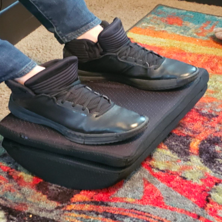 Another reviewer photo of their feet on the foot rest adjusted at a different angle