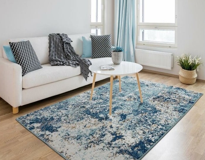 blue area rug in the middle of a living room under a coffee table