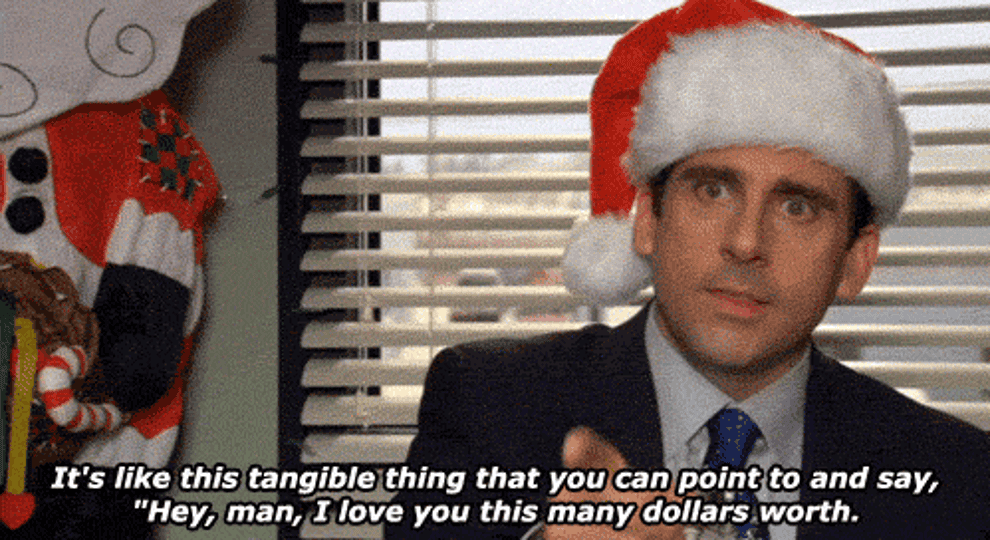 a gif of michael scott from the office wearing a santa hat and saying &quot;it&#x27;s like this tangible thing that you can point to and say hey man I love you this many dollars worth&quot;