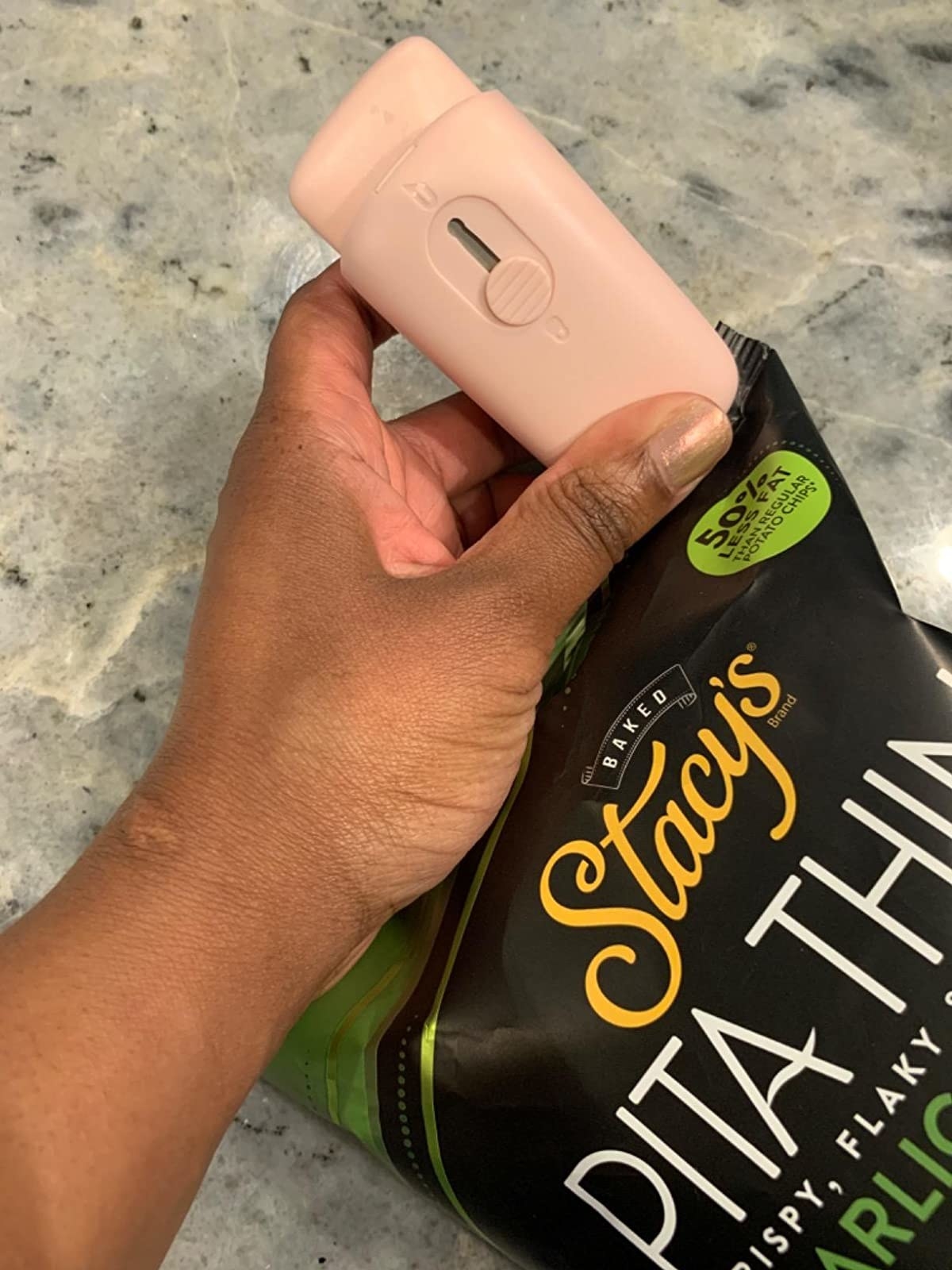 reviewer using the pink bag sealer to close a bag of chips 