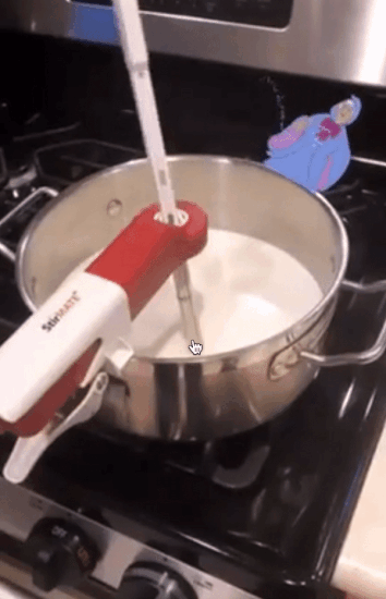 reviewer gif with the StirMate clipped to the side of the pot with an arm across and stick in the pot automatically stirring the white liquid inside