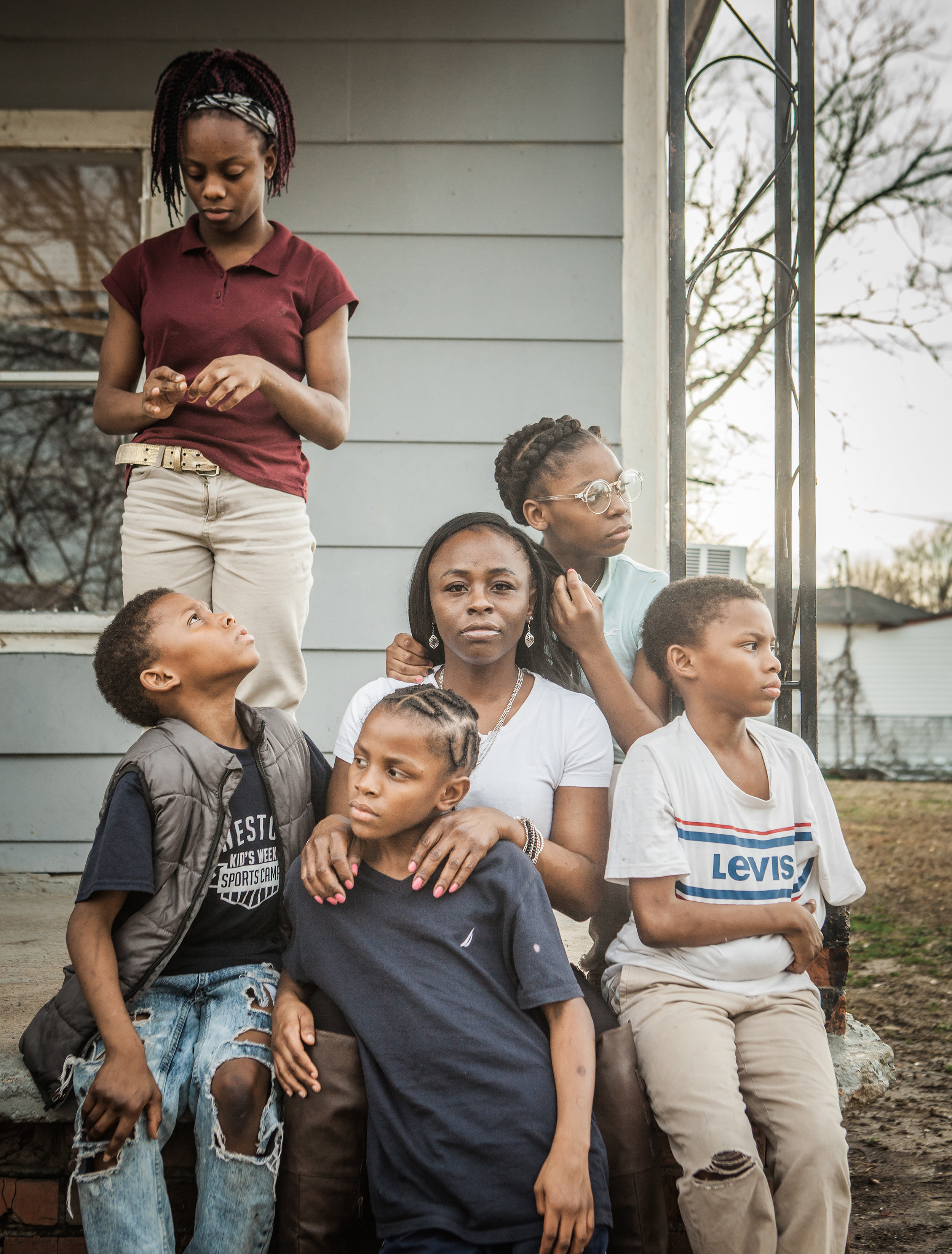 A mother and her five children on a porch 