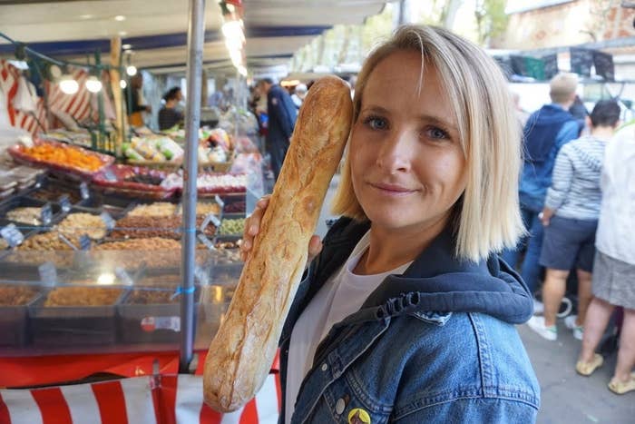 Woman holds a baguette in an outdoor market