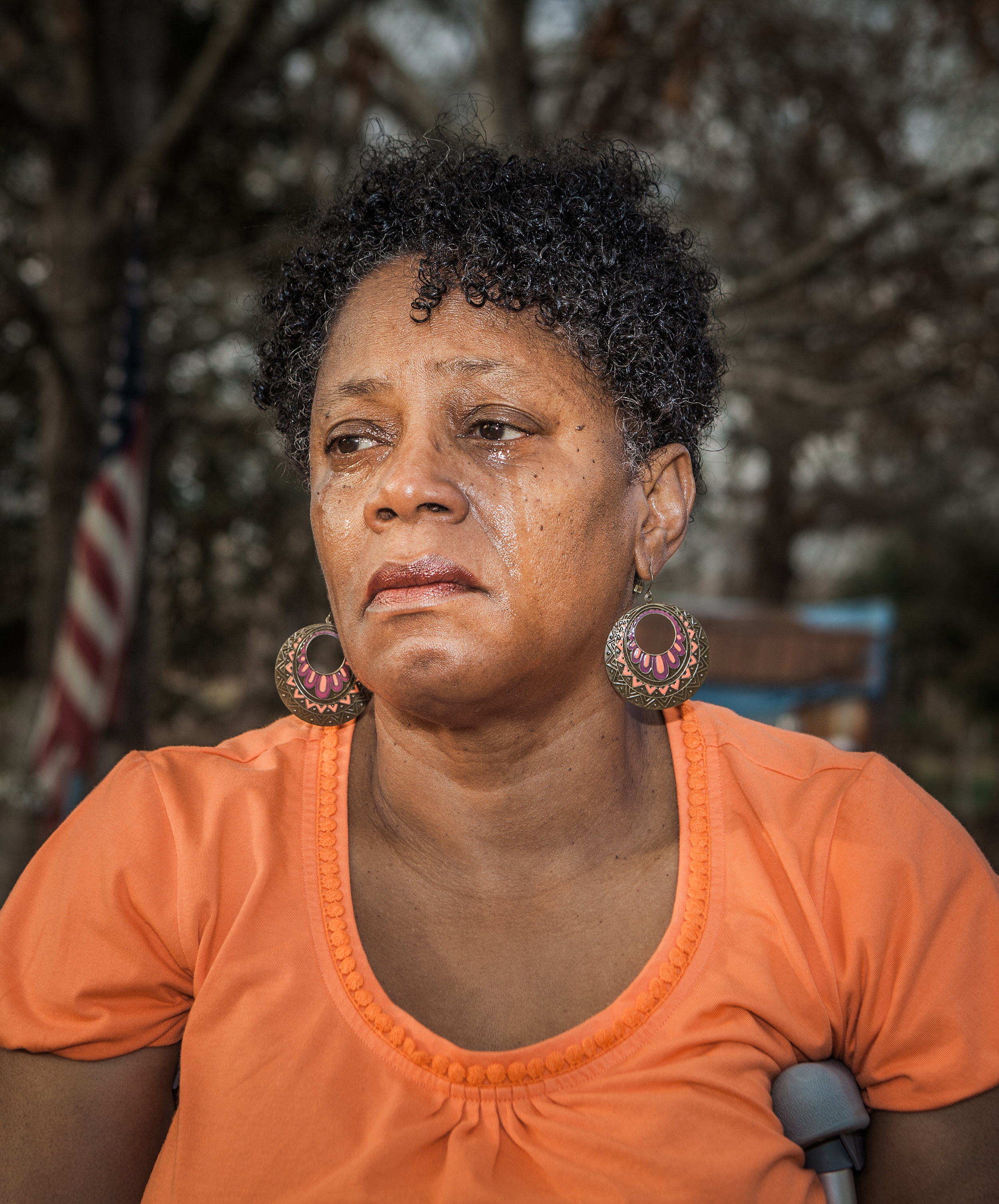 A woman crying in front of the American flag 