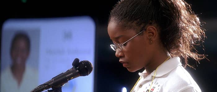 A young girl stands at a microphone