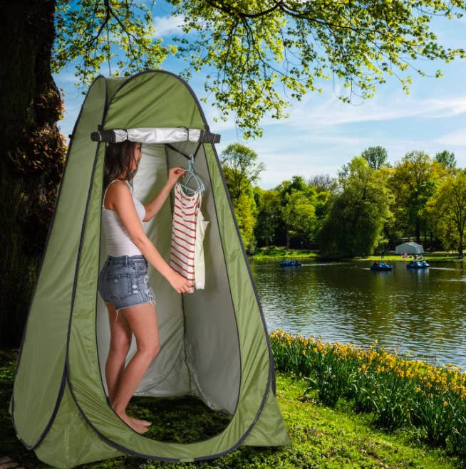 Model changes clothes in green pop-up privacy tent