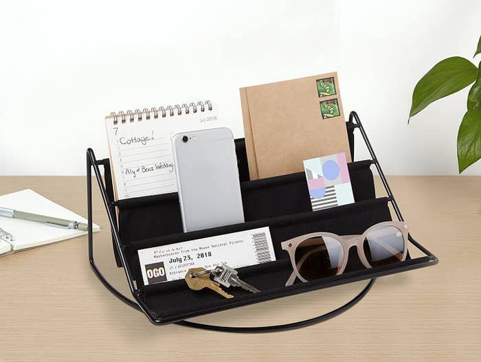 The felted hammock on a desk containing sunglasses, a phone, mail, and some keys