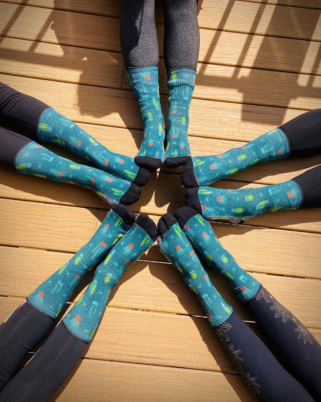 Several pairs of feet wearing the teal socks