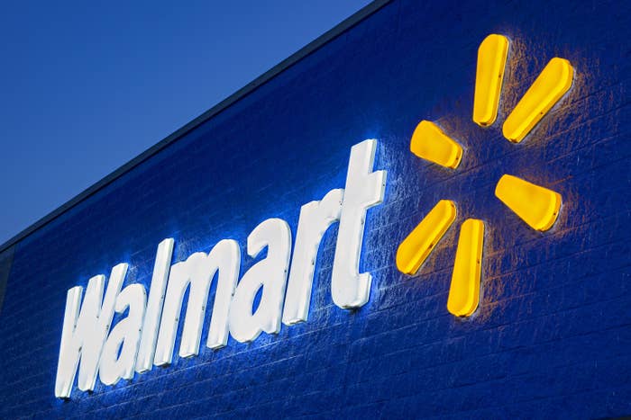 Lit up white and yellow Walmart sign on building exterior