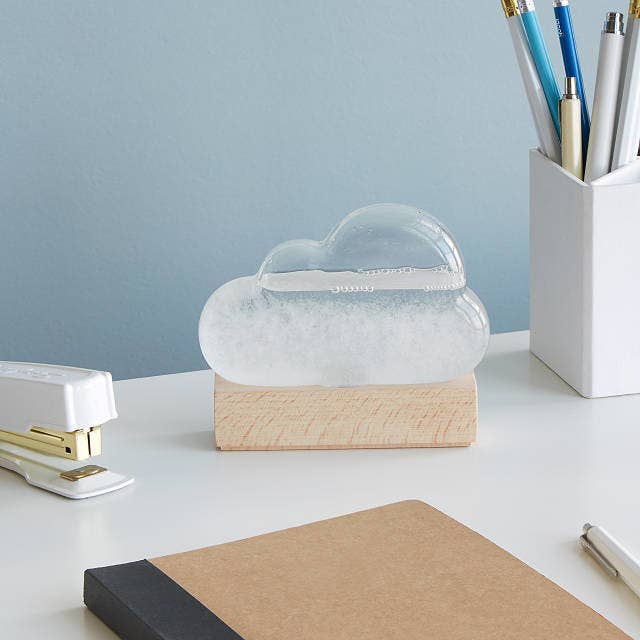 The clear cloud-shaped device with wood base