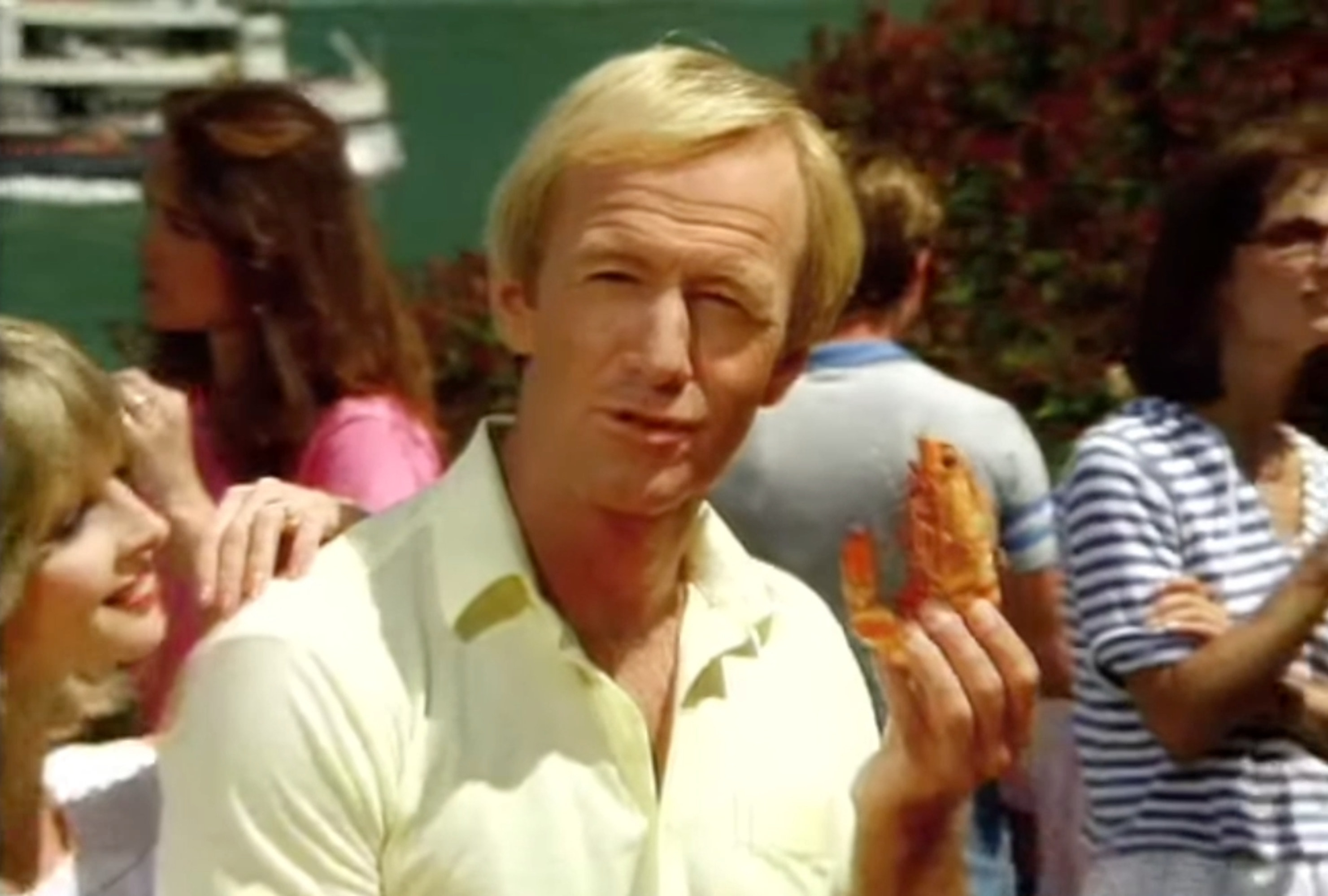 Paul Hogan holding a prawn up in his hand