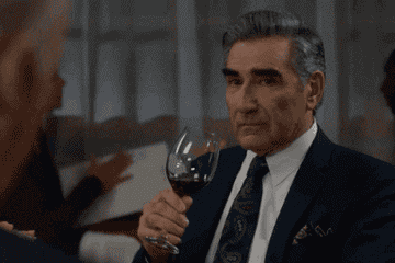 Johnny Rose in &quot;Schitt&#x27;s Creek&quot; drinking a glass of red wine.