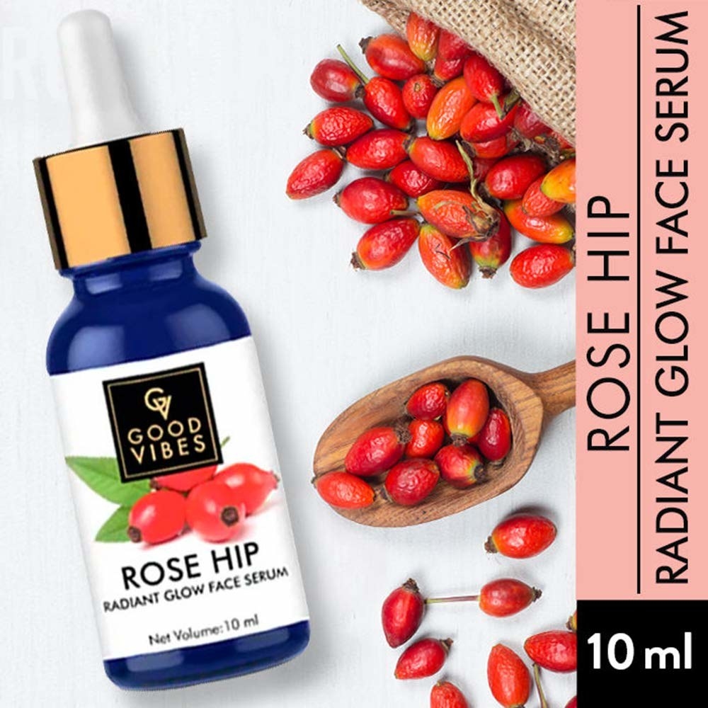 The serum bottle and a handful of rose hips scattered next to it.